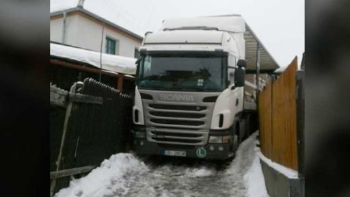 Kamion uvízlý mezi domy